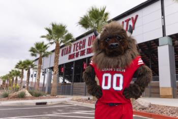 mascot in front of university sign