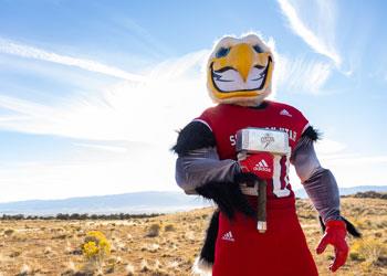 mascot with helicopter toy in desert